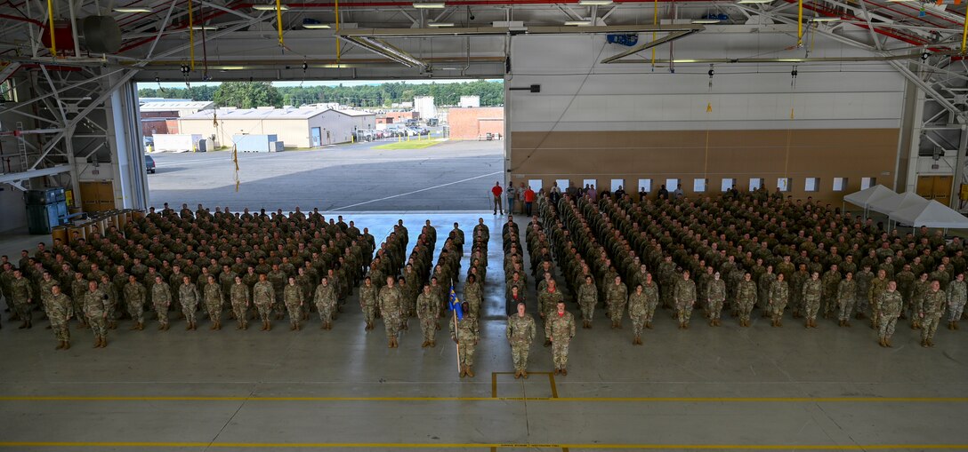 Members of the 104th Fighter Wing stand at attention in a mass formation during the 25th anniversary of 9/11 memorial ceremony at Barnes Air National Guard Base in Westfield, Mass., Sept. 11. The wing gathered to reflect on the lives lost and the impact the attacks had on the community.  (U.S. Air National Guard photo by Tech. Sgt. Leilani Peltz)