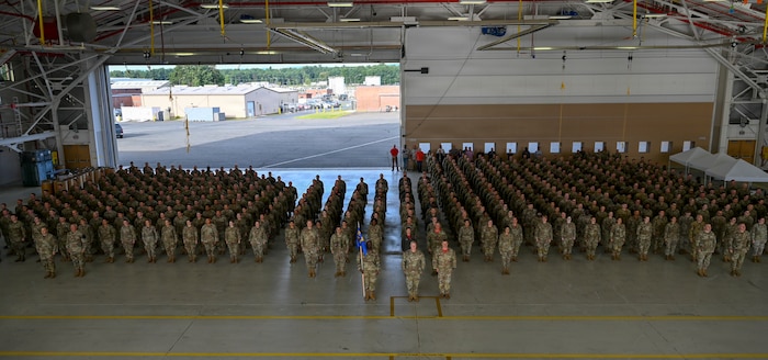 Members of the 104th Fighter Wing stand at attention in a mass formation during the 25th anniversary of 9/11 memorial ceremony at Barnes Air National Guard Base in Westfield, Mass., Sept. 11. The wing gathered to reflect on the lives lost and the impact the attacks had on the community.  (U.S. Air National Guard photo by Tech. Sgt. Leilani Peltz)