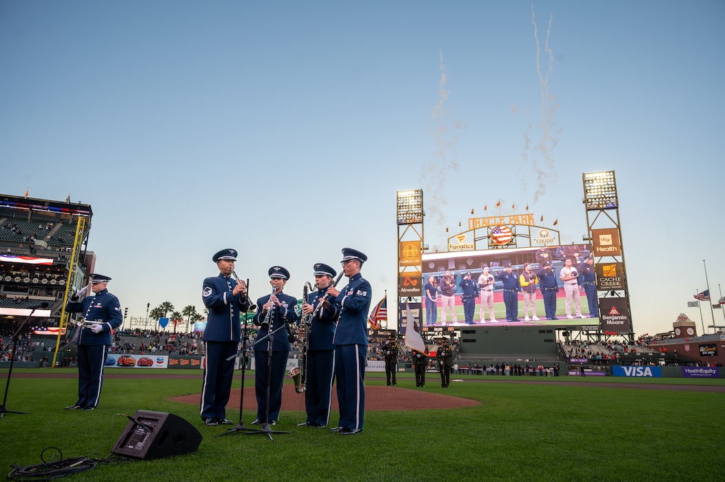 Airmen perform national anthem before baseball game.