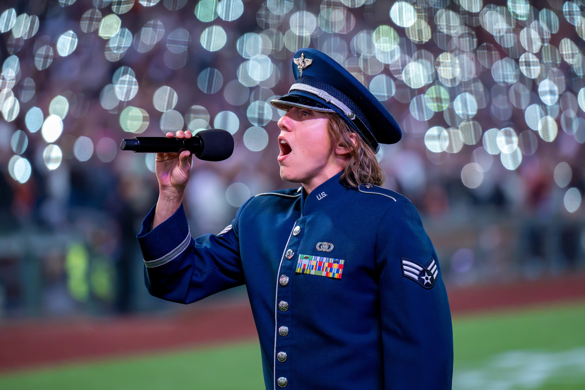 Airman sings at baseball game.
