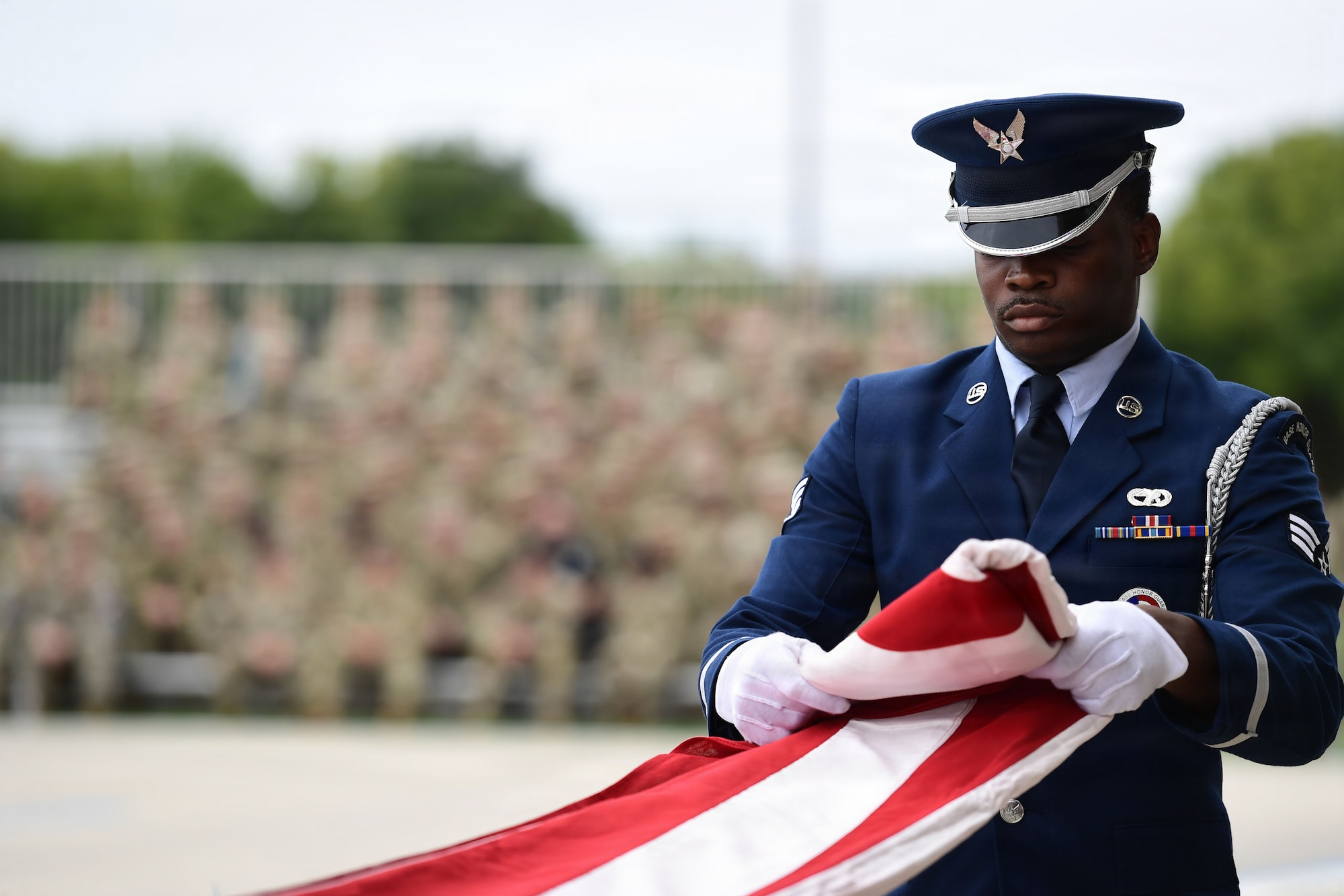 A man wearing a U.S. Air Force uniform folds a U.S. Flag.