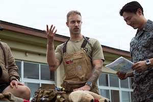 U.S. Air Force Staff Sgt. Hunter Tome, 374th Security Forces Squadron military working dog handler, demonstrates a canine injury assessment to Japan Air Self-Defense Force members.