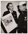 Original caption reads: "Coast Guardsman Robert J. Sargent, Chief Photographer's Mate. . . . .shows Coast Guardsman Clyde R. Wilson, Motor Machinists Mate. . . . .a picture of the battle-blasted Coast Guard-manned LC[I-85] that Wilson served on during the Invasion of Normandy.  Both men are veterans of the invasions of Sicily, Italy, and Normandy."

Scan courtesy of Ray Rebmann, Jr. & "Fred's Place Tribute Group."